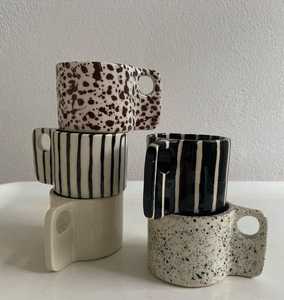 Juego de tazas de cerámica hechas a mano con patrones a rayas y salpicados, diseño minimalista para uso doméstico. - Product Image 1