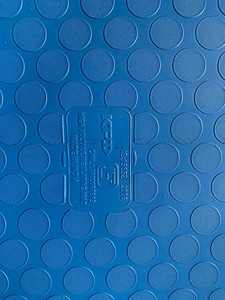 Tapis anti-fatigue bleu placé dans une atelier industriel moderne avec des étagères à outils et des machines créant un espace de travail propre - Product Image 2