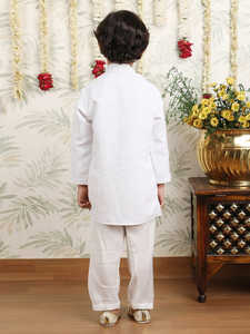 Niño con kurta y pijama blancos en pose de pie lateral, sonriendo, fondo festivo, decoración floral, elegante, tradicional, retrato infantil - Product Image 2