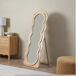 A modern, freestanding floor mirror showcases a unique, wavy natural wood frame with an <b>easel</b> available at wholesale prices. - Product Image 1