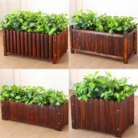 Grand bac à plantes rectangulaire en bois avec feuillage vert dense, jardinière surélevée rustique pour extérieur, aménagement paysager décoratif pour la maison