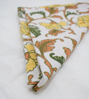 Serviette en lin blanc faite à la main avec imprimé floral traditionnel dans les tons orange et jaune forme carrée pour décor de table salle à manger