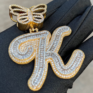 Pendentif initial K de luxe en moissanite sertie de pierres, avec attache papillon, finition dorée, bijoux hip-hop, en gros plan - Product Image 1