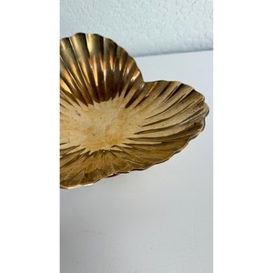 La superficie dorada pulida de un tazón de latón refleja la luz como un pequeño sol dorado sobre la mesa. - Product Image 3