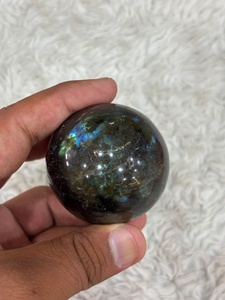 Sphère de cristal de labradorite aux reflets gris fumé, iridescence bleue, géométrie polie, motifs minéraux fluides - Product Image 1