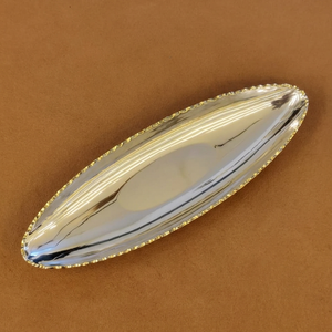 Ce plateau élégant finition argentée présente un design ovale pointu et une bordure dorée détaillée, offrant un luxe pour le service et la décoration. - Product Image 1