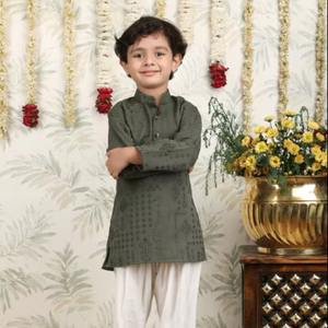 Niño con kurta y pijama tradicionales, de brazos cruzados, fondo festivo con decoración floral, retrato de niño sonriente - Product Image 1