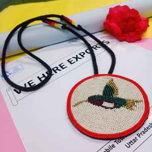 Collier pendentif oiseau artisanal perlé avec perles colorées vertes, dorées, violettes, blanches et rouges et cordon long pour un style artistique et culturel - Product Image 1