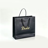 Sac cadeau en papier noir personnalisable de qualité supérieure avec impression de logo doré métallique et poignées en ruban plat pour l'emballage de produits de luxe