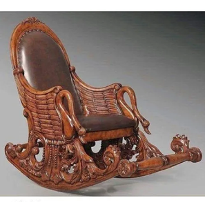 Fauteuil à bascule en bois de style vintage, avec accoudoirs sculptés en forme de col de cygne, côtés en forme d'ailes et assise en cuir brun foncé. - Product Image 1