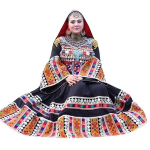 Portrait saisissant d'une femme assise portant une magnifique robe maxi traditionnelle Kuchi noire comme du charbon, avec un design extraordinaire. - Product Image 1