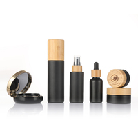 Set Kemasan Kosmetik Kaca Hitam Kustom dengan Tutup Bambu untuk Botol dan Stoples Perjalanan Label Pribadi Perawatan Kulit