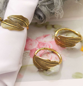 Des anneaux de serviette en plumes dorées détaillés ajoutent une touche vintage et fantaisiste à toute réunion. disponibles à prix de gros. - Product Image 1