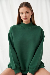 Femme confiante portant un sweat-shirt vert émeraude riche à col montant, coupe ample parfaite, dans un éclairage de studio clair. - Product Image 1