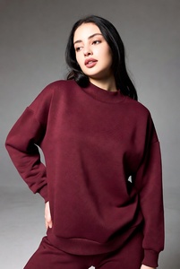 Jolie jeune femme élégante portant un sweat-shirt à col montant bordeaux riche et à manches longues, coupe confortable, debout avec confiance dans un studio. - Product Image 1
