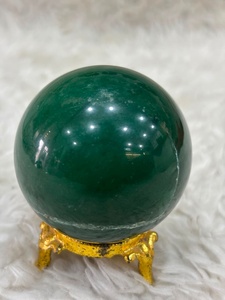 Sphère de jade vert avec une riche coloration émeraude, variation crémeuse, surface lisse et arrondie, polissage raffiné et intemporel. - Product Image 1