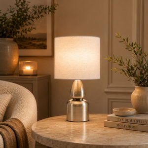 Aurora Sculpted Metal Table <b>Lamp</b> with Linen Drum Shade Antique Brass Finish Soft Ambient Lighting for Elegant Interiors - Product Image 1