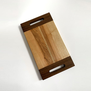 Planche à découper moderne en bois bicolore avec deux poignées intégrées et une finition à grain contrasté pour couper les légumes - Product Image 1