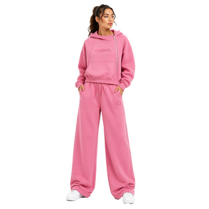 Ensemble de survêtement rose pour femme avec sweat à capuche asymétrique zippé, veste oversize et pantalon de survêtement à coupe ample avec logo embossé ton sur ton et impression DTG - Product Image 1