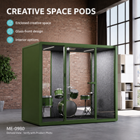 Pod de bureau moderne et créatif vert avec façade en verre, intérieur gris et espace de travail flexible pour musique ou studio