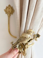 Attache-rideau doré luxueux à motif floral et d'oiseaux, parfait pour les fenêtres de la salle à manger, crée une ambiance sophistiquée.