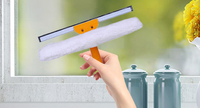 Outil de nettoyage de vitres à poignée orange Poignée en plastique avec grattoir en caoutchouc et tampon de nettoyage blanc flou