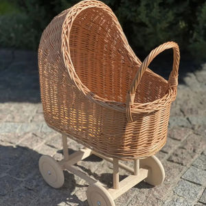 Este cochecito de juguete para niños está hecho de ratán natural. Es una carriola alta para muñecas con cuatro ruedas y un mango. - Product Image 1