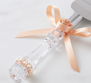 Elegante juego de cuchillo y espátula para pastel de bodas con mangos de cristal y detalles de cinta color melocotón para uso en fiestas. - Product Image 2