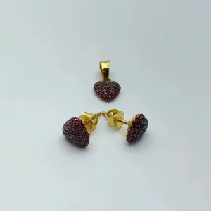 Hermoso conjunto de joyería de oro que incluye un colgante en forma de corazón y aretes a juego adornados con piedras rojas brillantes. - Product Image 1