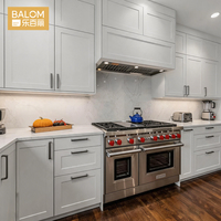 Meubles de cuisine modernes BALOM, portes en panneaux blancs brillants, plan de travail noir, quincaillerie noire pour projets de cuisines sur mesure.