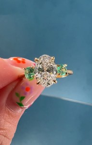 Bague à trois pierres en or 14 carats avec diamant ovale de 3,01 carats cultivé en laboratoire et pierres précieuses vertes rondes latérales, idéale pour fiançailles, promesse, fête ou comme cadeau. - Product Image 4