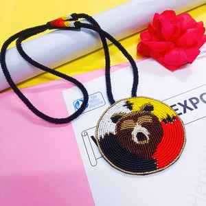 Collier pendentif visage d'ours perlé fait main avec perles noires, blanches, jaunes, rouges et brunes et cordon long pour un usage artistique et culturel - Product Image 1
