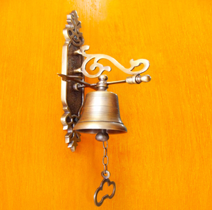 Cloche murale en laiton ornée d'un support décoratif à motifs roulés et d'une poignée à chaîne avec extrémité en forme de trèfle. - Product Image 1