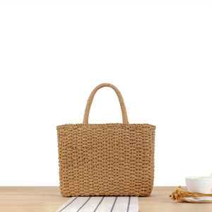 Experimente el lujo silencioso con este hermoso bolso de hilo natural que presenta una forma rectangular estructurada y una textura tejida cálida. - Product Image 1