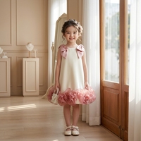 Gaun Putri Model A-Line Warna Ivory dari Tutupetti Refined Custom Girls Boutique, Tanpa Lengan, dengan Ruffle Organza Warna Blush dan Pita Besar