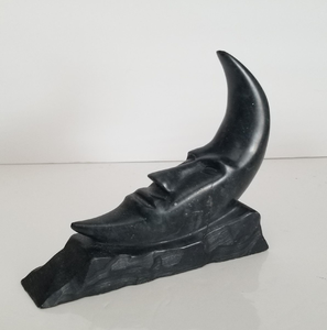 Smooth dark soapstone crescent moon figurine featuring a serene facial profile, available at wholesale prices. - Product Image 1