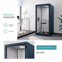 Cabine téléphonique de bureau moderne et compacte bleue avec porte en verre, étagère intérieure, tabouret blanc et espace de travail privé