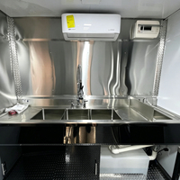 Remorque de cuisine mobile entièrement équipée avec plancha, comptoir de travail, armoires noires, prête pour la vente de hot-dogs, sandwichs, grillades et plats chauds