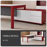 Bureau de direction moderne en forme de L avec armoire de rangement latérale, plateau blanc, cadre rouge et panneau de modestie gris en bois
