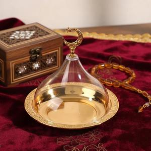 Plateau en métal finition or luxueux avec couvercle en verre et poignée en forme de croissant de lune pour servir des bonbons, des collations et des présentations festives, provenant d'Inde. - Product Image 1