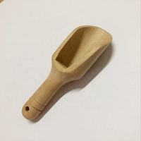 Cuchara de madera con mango largo disponible en varios tamaños, utilizada para medir, transferir y porcionar ingredientes secos finos o granulados.