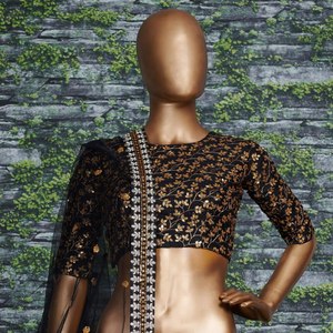 El lehenga negro intenso está cubierto con un intrincado bordado de lentejuelas doradas en forma de ramas, creando un patrón fluido y elegante para la recepción. - Product Image 3