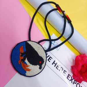 Collier pendentif oiseau noir perlé fait main, design circulaire avec détails bleus, blancs et oranges, pour un usage artistique et culturel - Product Image 5