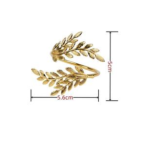 Anillos de servilleta de metal con diseño de hojas que añaden equilibrio visual a una mesa, anclando telas suaves con un elemento fuerte y pulido. - Product Image 3