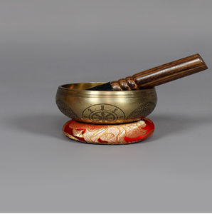 Brass singing bowl with polished golden rim and engraved Dharma wheel symbol on the exterior, available at wholesale prices. - Product Image 1