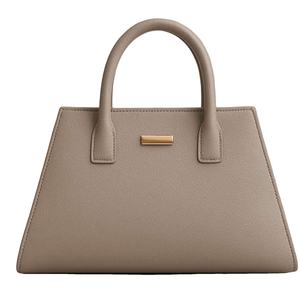 Bolso tipo satchel de cuero beige o color marrón pardo con un diseño minimalista y una barra metálica dorada. - Product Image 1