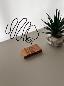 Escultura minimalista de rostro en alambre sobre base de madera, ideal para decoración de un rincón de lectura en el hogar y para combinar con libros como arte en la estantería. - Product Image 6