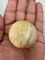 Bola batu akik Crazy Lace dengan pola bergelombang berwarna oranye krem dan abu-abu yang rumit, berbentuk bulat yang dipoles, dan unik.