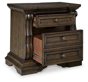 Esta es una mesita de noche Maylee de Ashley Furniture con un acabado en madera marrón oscuro y apliques ornamentales para uso en el dormitorio. - Product Image 2