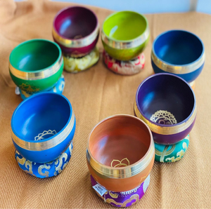 Juego de cuencos tibetanos de latón con símbolos de los siete chakras y cojines de seda, disponible a precios de mayorista. - Product Image 1